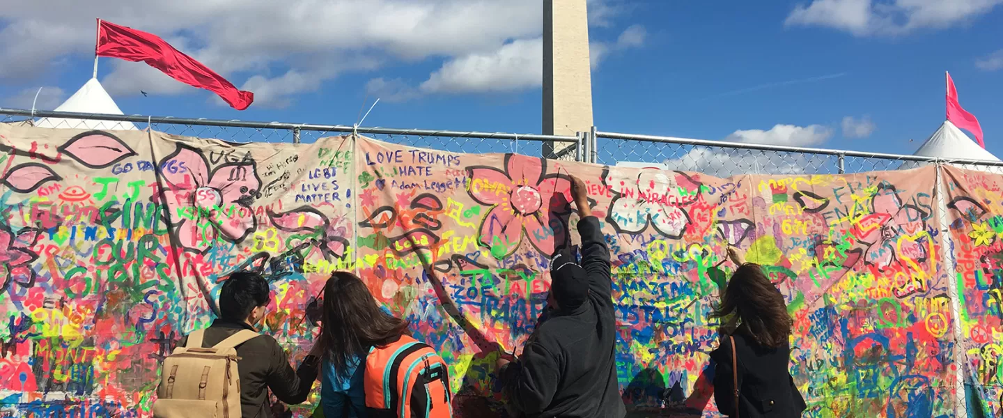 Students painting a mural in front of the Washington Monument