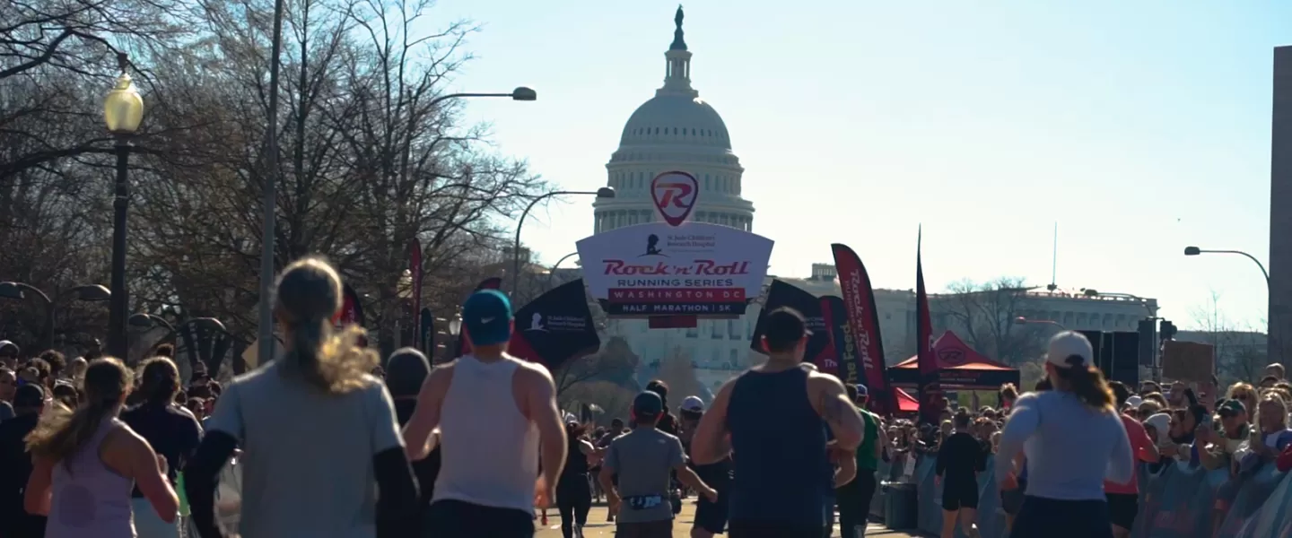 Runners participating in the Rock 'n' Roll Running Series in Washington, D.C., with the U.S. Capitol in the background.
