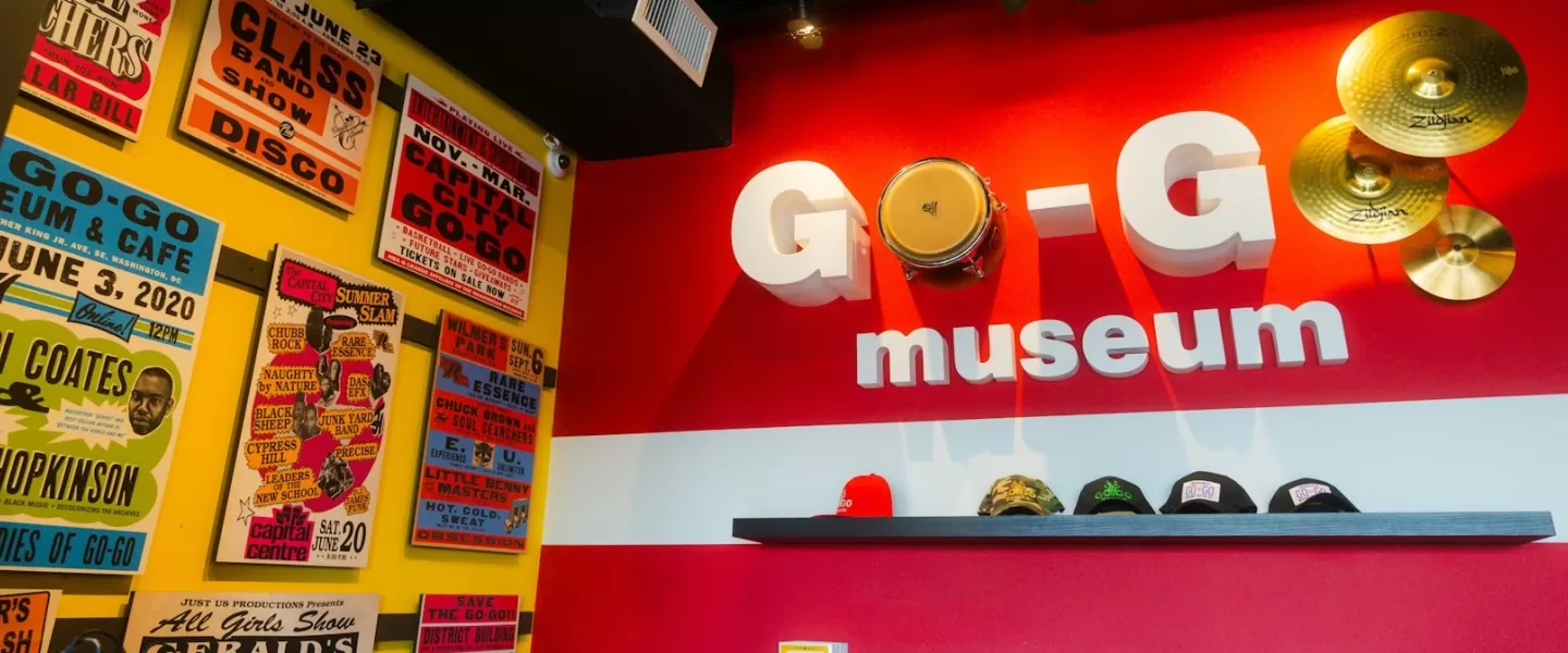 Uma exposição vibrante no Museu Go-Go em Washington, DC, com sinalização ousada, pratos e pôsteres de shows antigos.