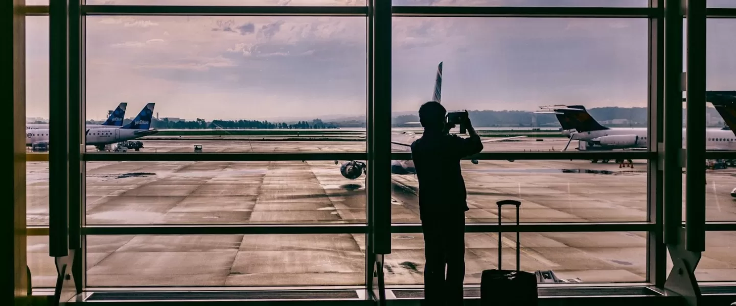 Traveler taking pictures of airplanes with luggage