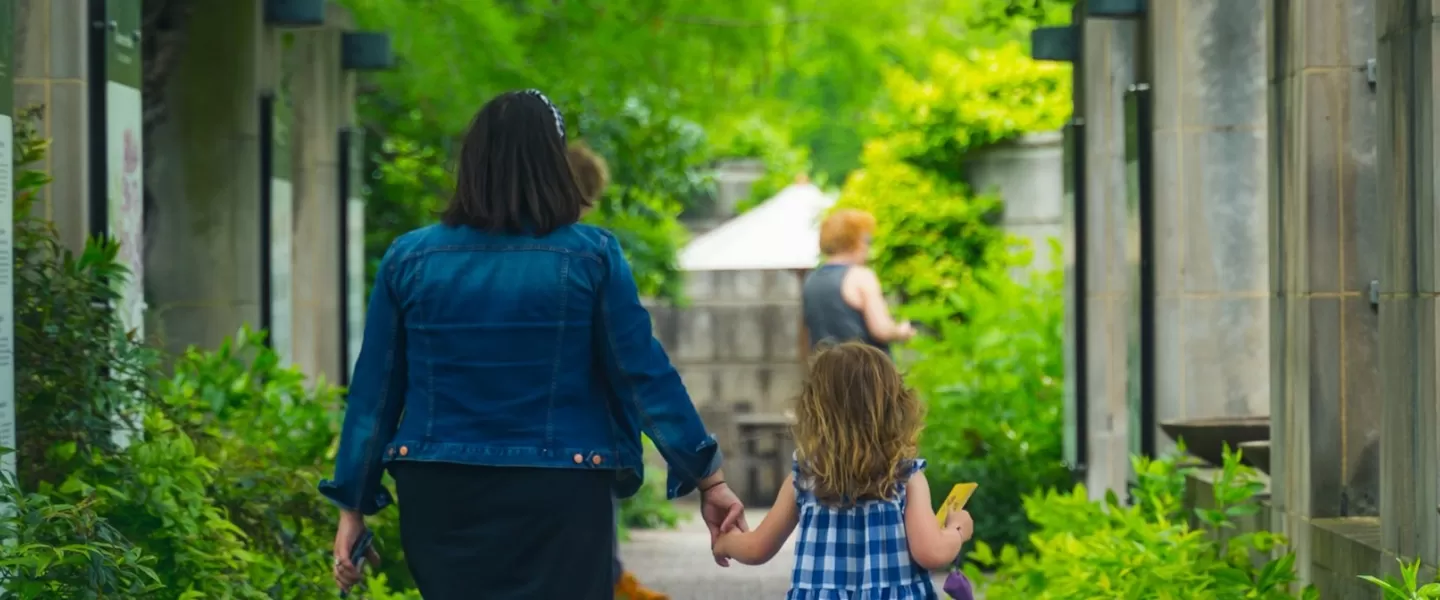 A mother and daughter walk along a path in the U.S. Botanic Garden. 