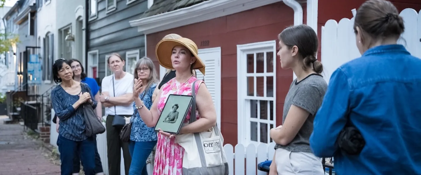 A tour guide speaks to a group during a historic walking tour in Georgetown, Washington, DC.