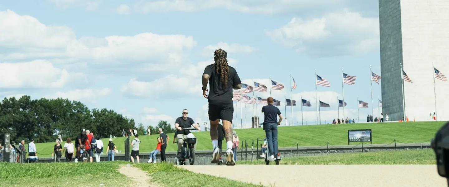 A man runs along the National Mall near the Washington Monument on a sunny day. 