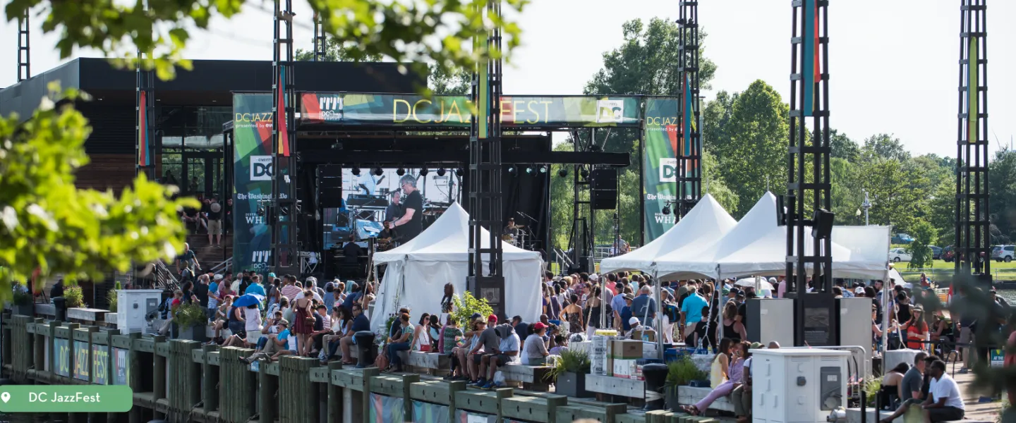 Crowd gathered at DC JazzFest waterfront stage with live music performances and festival tents.