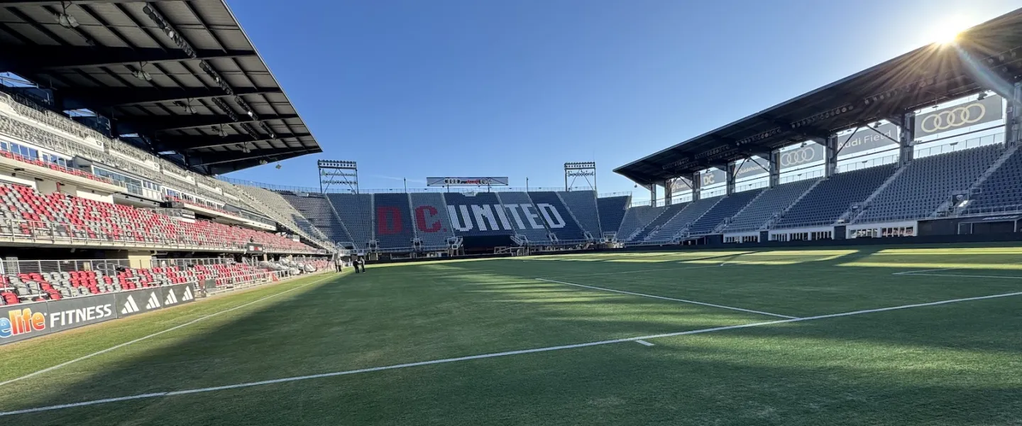 Panoramic photo of an empty soccer stadium with sun flare over the field