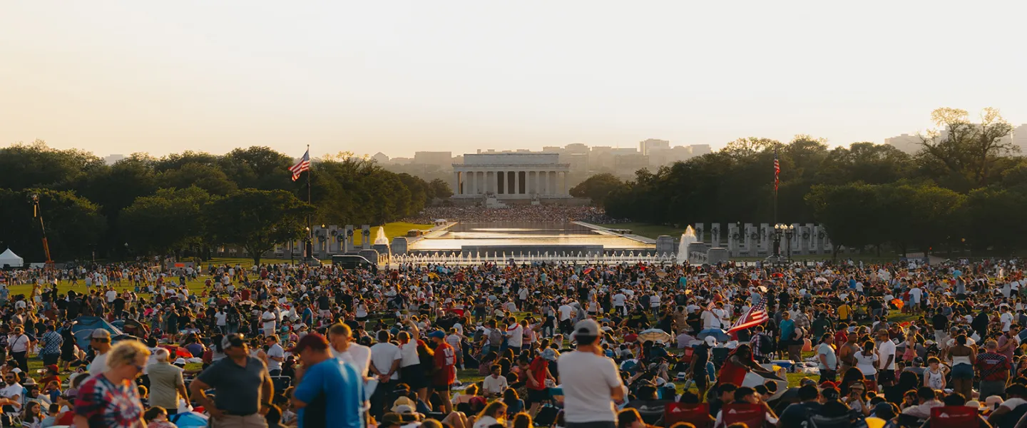 Large crowd gathered at sunset on the National Mall during an evening event. 