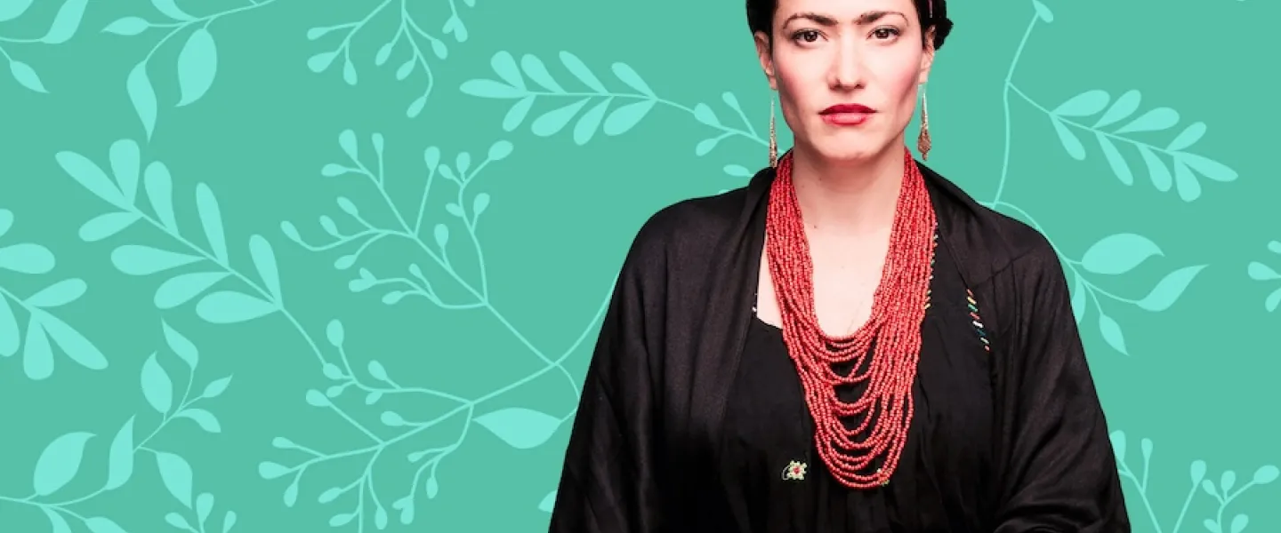 Frida Kahlo in black robe and red skirt on teal floral background
