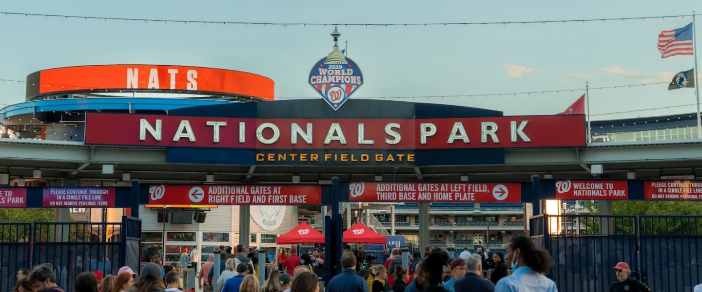 Photo of Nationals Park entrance with a crowd and large red NATs sign