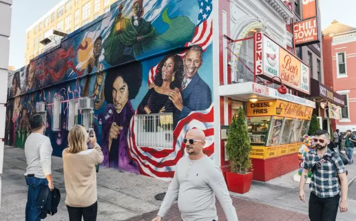 Des invités prennent une photo de la fresque murale du bol chili de Ben