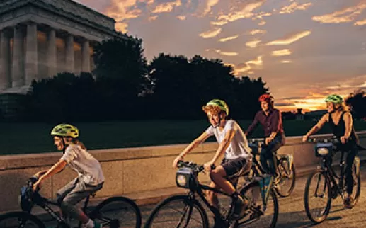 Família andando de bicicleta em frente ao Lincoln Memorial