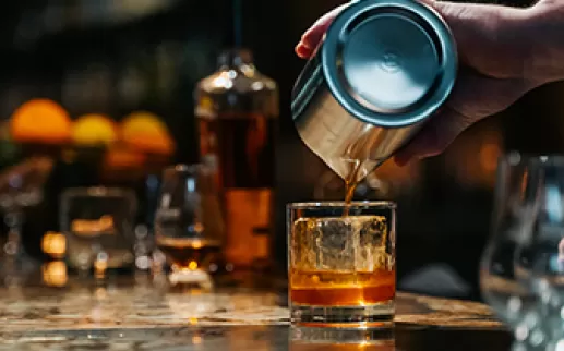 Barman versant du whisky dans un verre