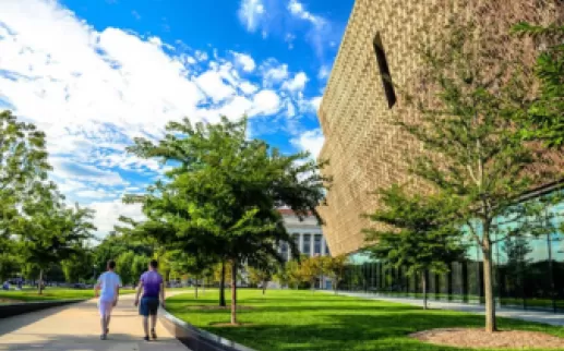 People walking outside in front of National Museum of African AmericanHistory and Culture 
