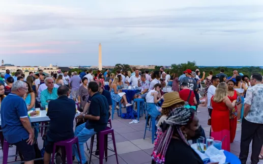 i partecipanti si riuniscono su un tetto con vista sul Monumento a Washington