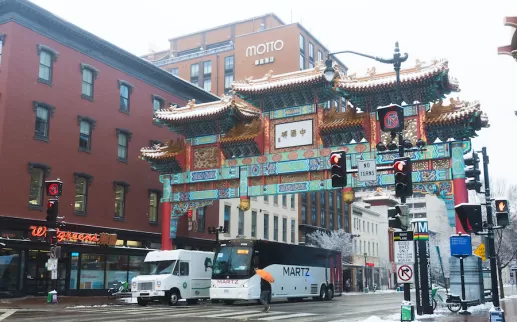 The iconic Chinatown Friendship Archway in Washington, DC, surrounded by snow-covered streets.
