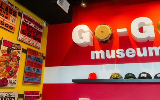 A vibrant display at the Go-Go Museum in Washington, DC, featuring bold signage, cymbals, and vintage concert posters.