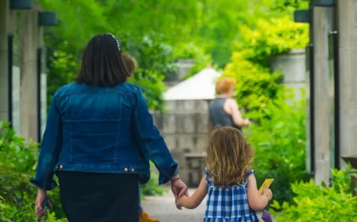 A mother and daughter walk along a path in the U.S. Botanic Garden. 