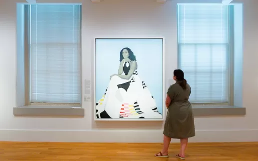 Uma mulher olha para um retrato estilizado de Michelle Obama no Museu de Arte Americana Smithsonian.