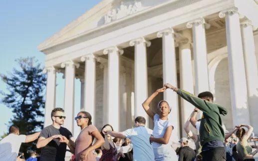 People dance on the steps of the Jefferson Memorial.