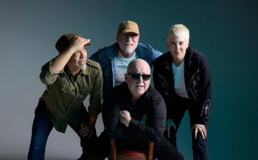 Group portrait of legendary alt-rock band PIXIES posing with casual confidence against a neutral studio backdrop.

