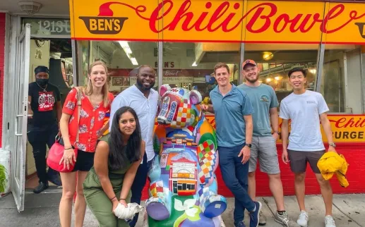 A group poses for a photo outside of Ben's Chili Bowl. 
