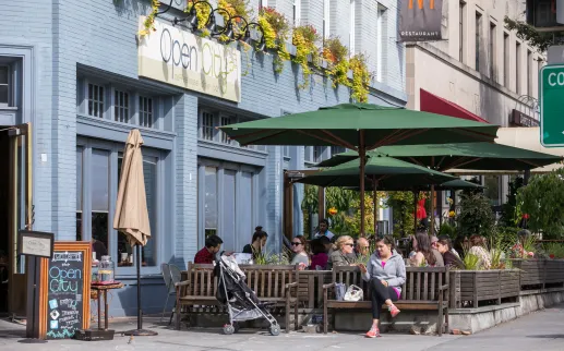 People enjoy outdoor seating at Open City in Washington, DC on a sunny day.
