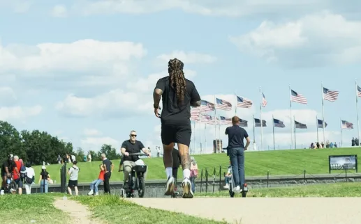 A man runs along the National Mall near the Washington Monument on a sunny day. 