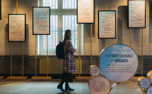 A visitor reads framed quotes in a museum gallery labeled “The Geffen Hall of Dreams.”