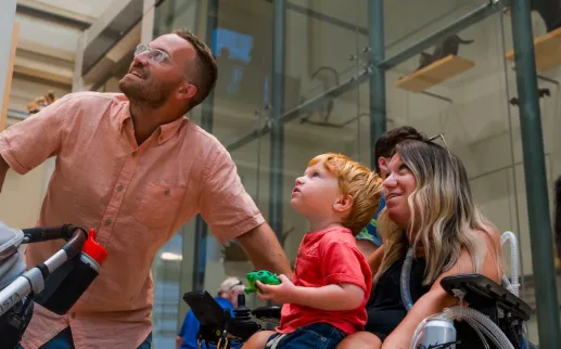 A family looks up at a soaring exhibit in a museum