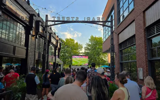 Crowd watching soccer on a screen on a closed-off city street