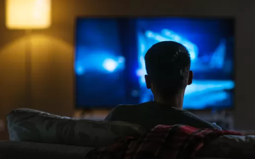 ragazzo di fronte alla televisione che lo guarda al buio