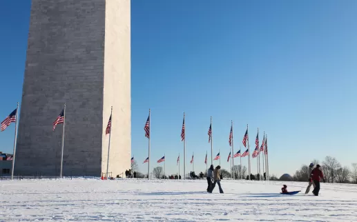 Famiglia sui terreni innevati del Monumento a Washington sul National Mall - Le migliori attività per la giornata sulla neve a Washington, DC