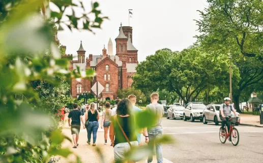 Visitors walking by the Smithsonian Castle on the National Mall in Washington, DC
