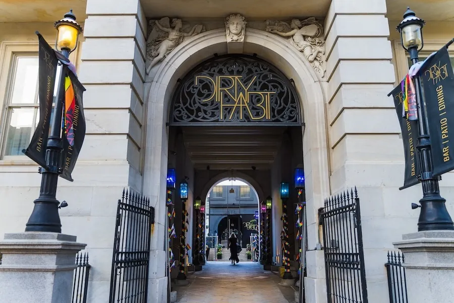 The entrance to Dirty Habit in Washington, DC, framed by an ornate iron archway.