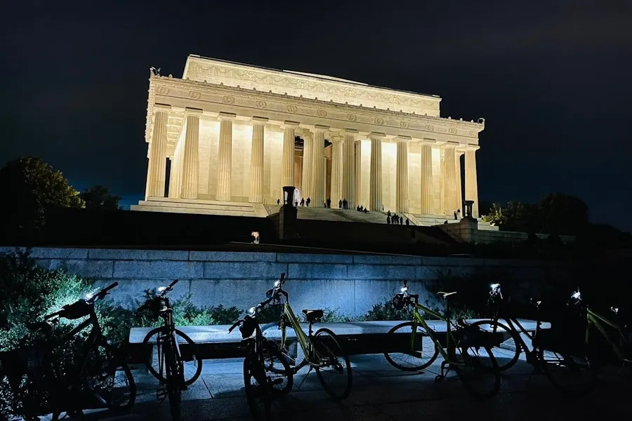 Um conjunto de bicicletas fica em frente ao Lincoln Memorial iluminado à noite.