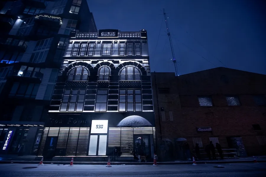 The exterior of the 9:30 Club aglow at night, with snow on the ground and on the window sills. 