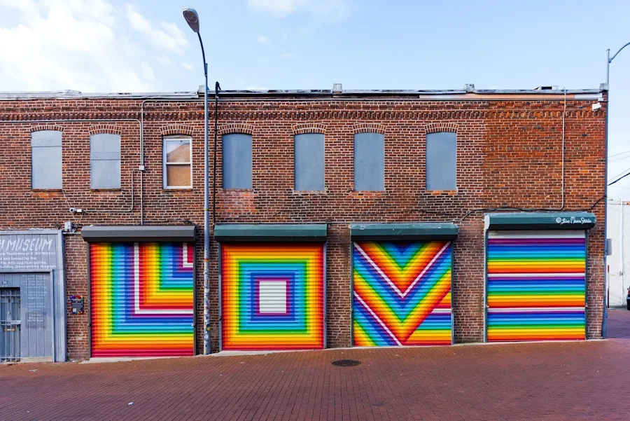 Four garage doors painted with bright, rainbow letters that spell LOVE. 