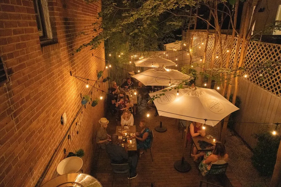 String lights and umbrellas create a romantic outdoor dining scene at Apéro in Washington, DC’s Georgetown neighborhood.