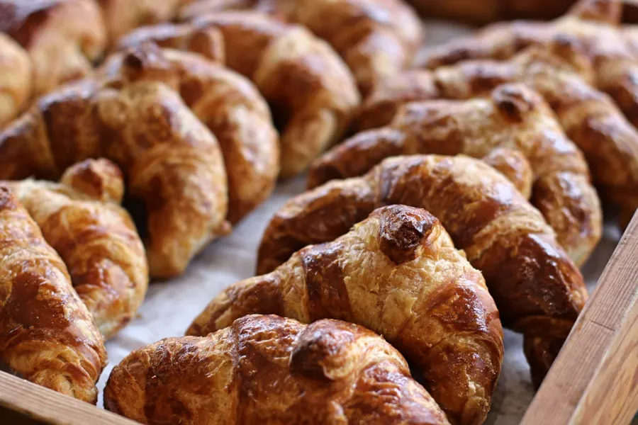 Golden croissants stacked on trays at Patisserie Poupon in Washington, DC’s Georgetown neighborhood.        Ask ChatGPT