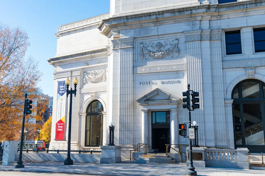 The grand stone exterior of the Smithsonian National Postal Museum on a sunny day.