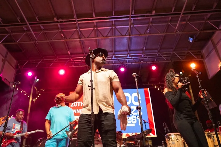 Musicians perform on stage under colorful lights at DC JazzFest.