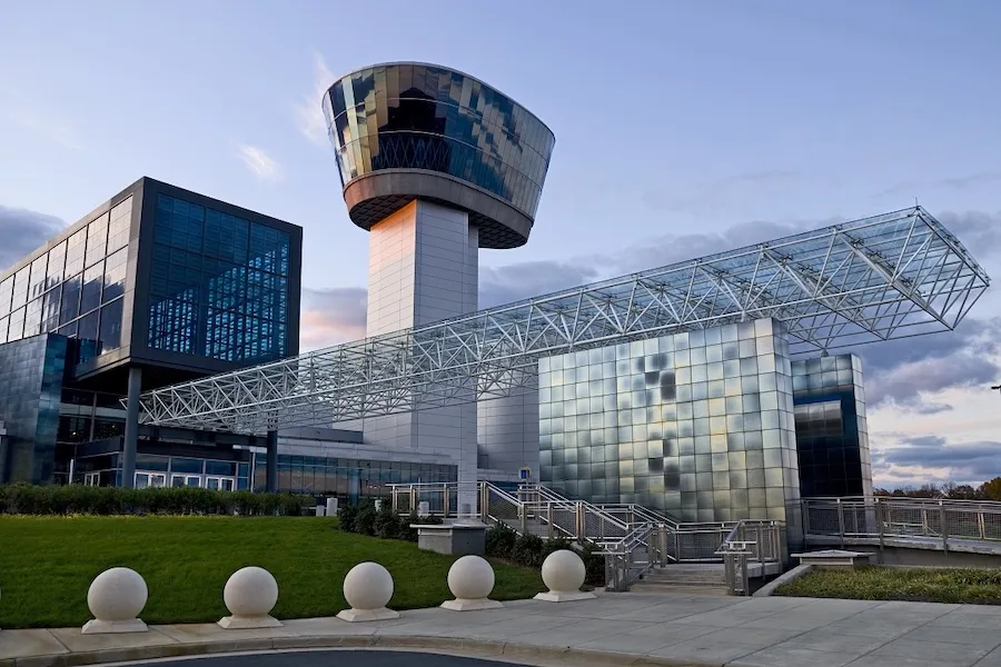 Exterior of the Smithsonian Udvar-Hazy Center with glass facade and observation tower in daylight.