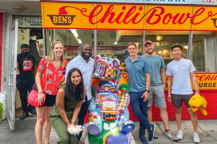 A group poses for a photo outside of Ben's Chili Bowl. 