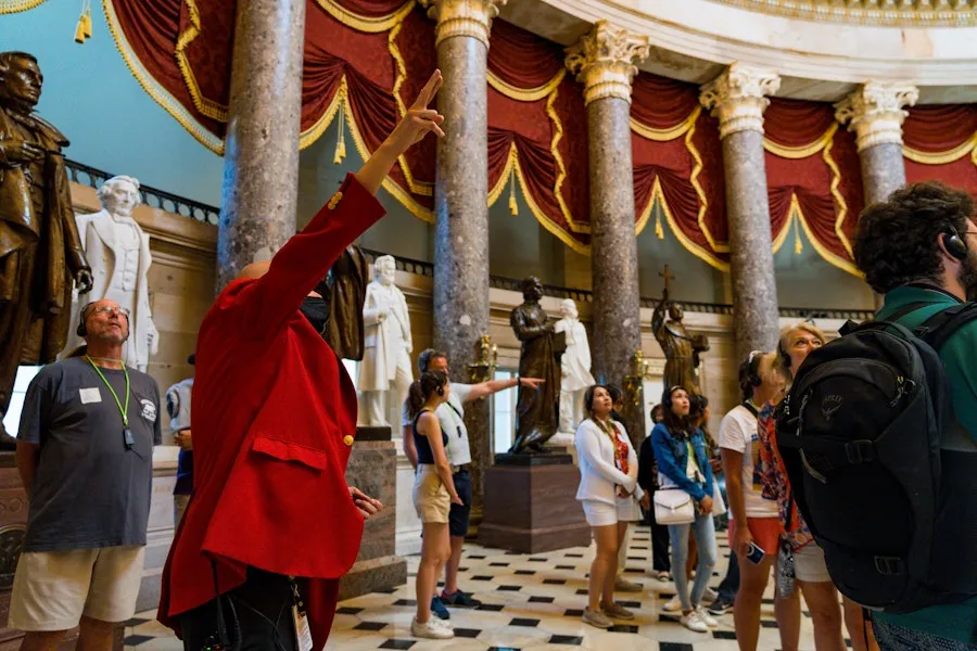 A guide gestures to statues while leading a tour through the National Statuary Hall inside the U.S. Capitol.