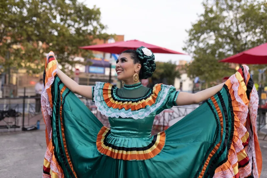 A folklórico dancer in a green traditional dress holds her skirt wide during an outdoor cultural performance in Washington, DC.