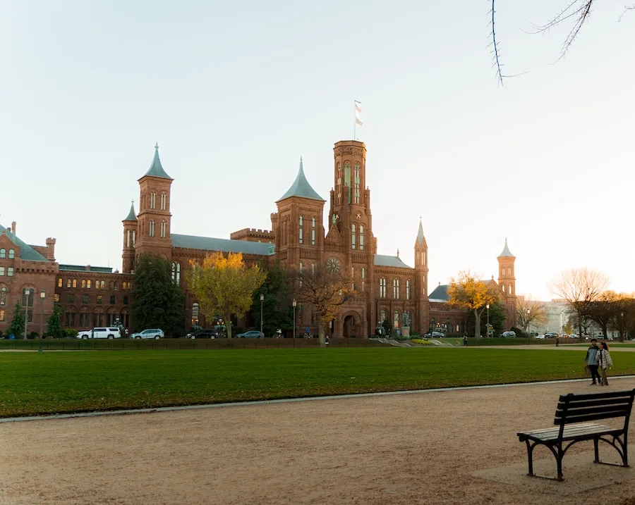 A view of the Smithsonian Castle across the National Mall in golden, summer light.