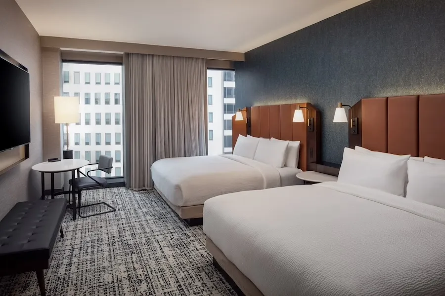 Tempo by Hilton Washington DC hotel room with two queen beds, desk, and city view through window
