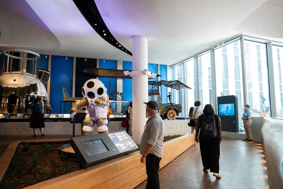 Visitors viewing exhibits in a modern museum with a large astronaut display