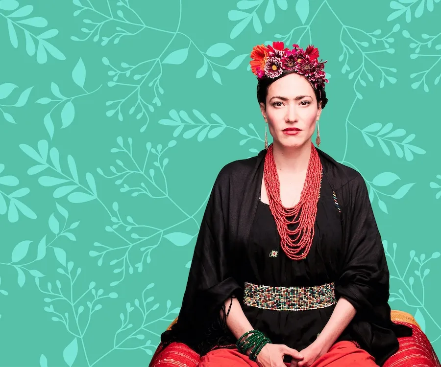 Frida Kahlo in black robe and red skirt on teal floral background
