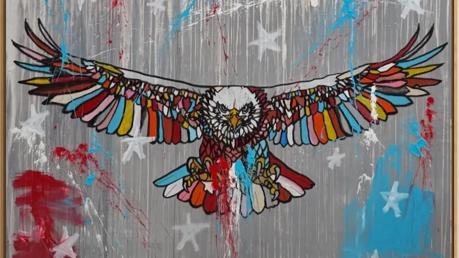 Colorful mural of a bald eagle on a gray wall with stars