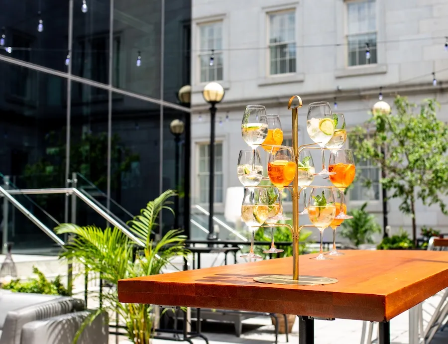 Outdoor patio with orange table and hanging wine glasses outside modern building